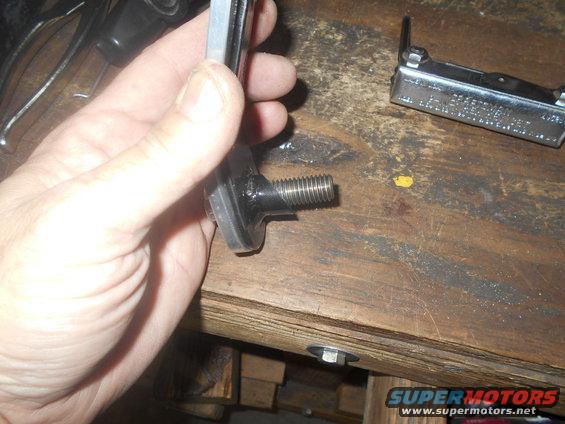 Hand holding sway bar end link with threaded bolt
