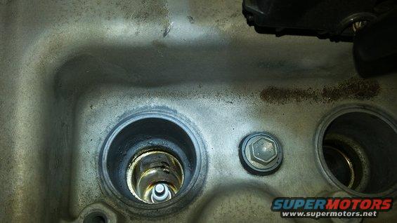 Close-up of a spark plug well with a spark plug visible inside
