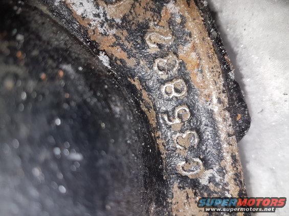 Close-up of a rusty metal part with stamped numbers C35832