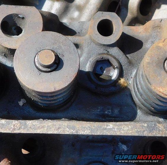 Close-up of engine cylinder head showing valve springs, retainers, and a valve stem