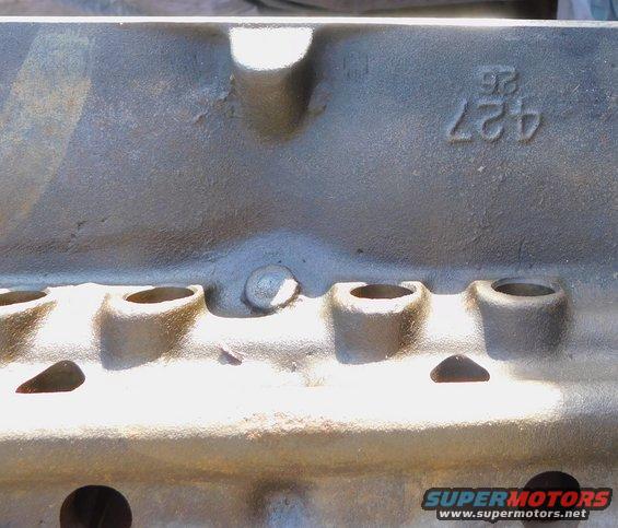Close-up of a cast iron engine block with '427' and '26' stamped on it