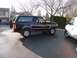1995 Ford Bronco - A black 1995 Ford Bronco is parked on an asphalt surface next to a white van.