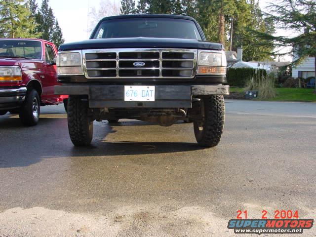 Front view of a black Ford truck with a red Ford truck to its left. License plate reads 676 DAT