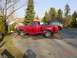 1992 Ford F-150 - A red 1992 Ford F-150 pickup truck is parked on a paved surface next to a black SUV.
