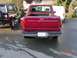 1992 Ford F-150 - Rear view of a red 1992 Ford F-150 pickup truck parked on a wet asphalt surface.