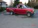 1992 Ford F-150 - This red 1992 Ford F-150 pickup truck is shown from a 3q-front angle, with another vehicle visible behind it.