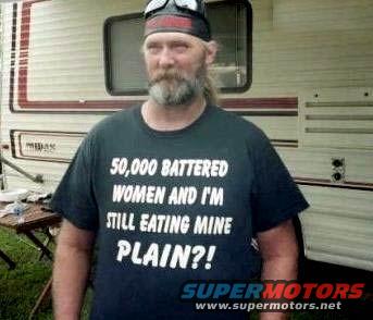 Man in black t-shirt with white text, standing in front of an RV