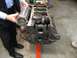 1968 Mercury Cougar - An engine block is shown on a stand, with a person holding a component near it.