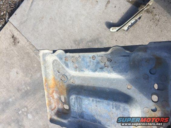 rusted metal bracket with multiple bolt holes and some rust spots