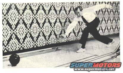 Man bowling in a bowling alley with a diamond pattern wall and a bowling ball on the lane