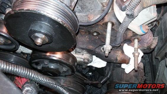 Engine pulleys and mounting bolts with white rags. Watermark reads SUPERMOTORS.NET