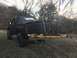 1989 Ford Bronco - This lifted pickup truck features a tow hitch attachment and a soft top cover over the bed.