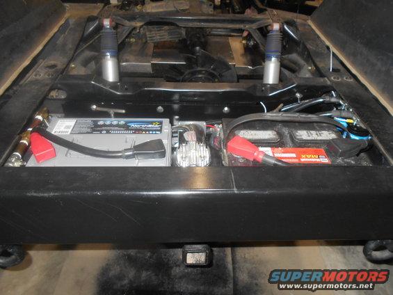 Vehicle chassis with two batteries, wiring, and shocks visible