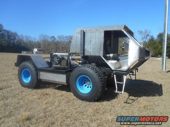 Custom-built off-road vehicle with large tires and a metal cab