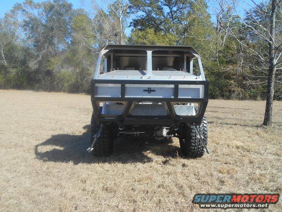custom off-road vehicle, rear view, with large tires and roll cage