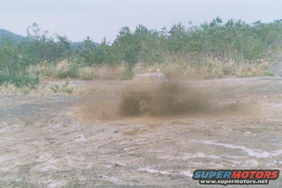 Truck splashing through mud puddle, front view