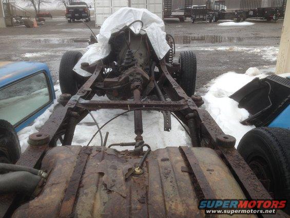 Rusted chassis and drivetrain with fuel tank visible