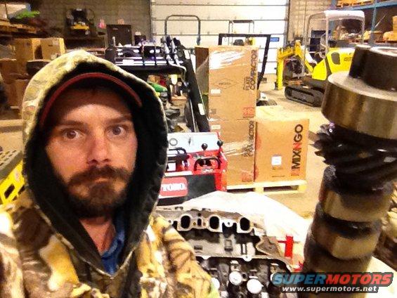 Man in workshop with engine parts and construction equipment