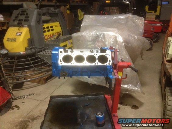 Blue engine block on red stand in workshop