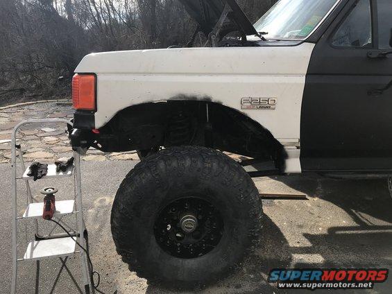 1989 Ford F-250 fender with "F250" badge, large off-road tire, and ladder with tools