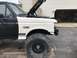 1989 Ford Bronco - This truck has a two-tone paint job and is undergoing some work, with the hood open and front bumper removed.
