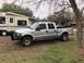2004 Ford F-150 - This silver 2004 Ford F-150 crew cab pickup truck is seen parked in a grassy area next to a recreational vehicle.