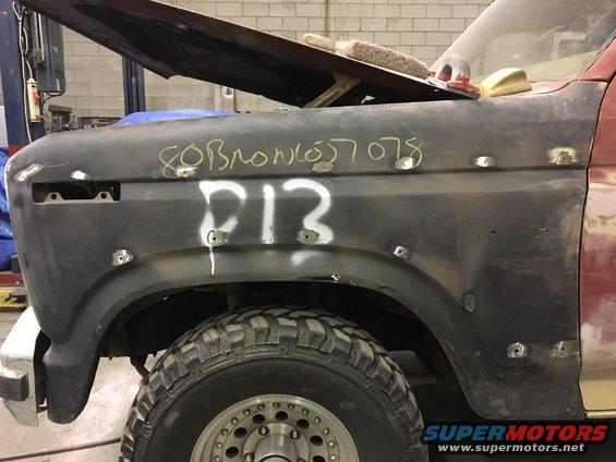 Ford Bronco fender with '80 Bronco 057078' and 'P13' written on it, undergoing repairs