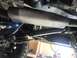1989 Ford Bronco - Close-up view of the undercarriage, focusing on the driveshaft and exhaust system.