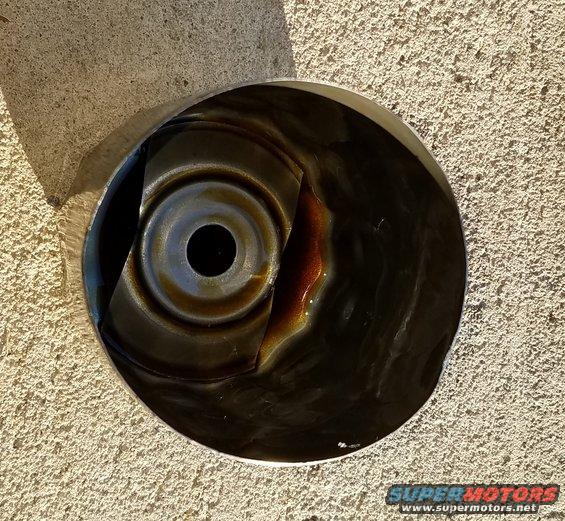 Close-up of a dirty oil pan with some oil residue inside