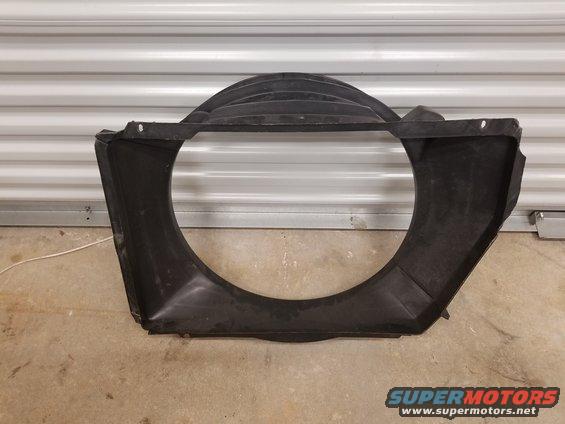 Black plastic radiator fan shroud with a large circular opening