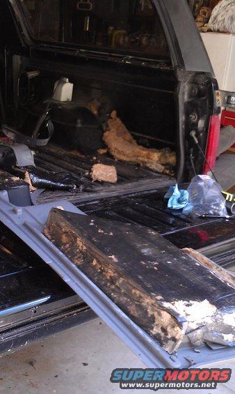 Interior of a vehicle with rear cargo area disassembled, showing removed insulation and parts