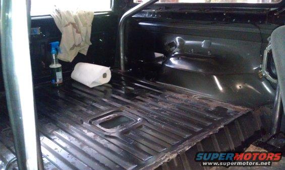 Interior floor of a vehicle with a roll bar, paper towels, and a spray bottle