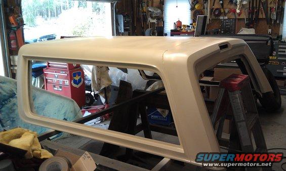 Cream-colored Ford Bronco topper in a garage, resting on sawhorses