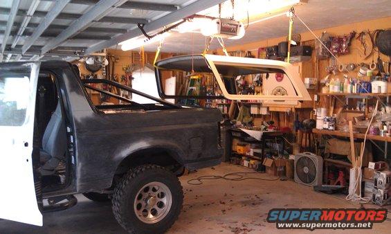 Dark gray Ford Bronco SUV, side view, parked indoors with warm lighting