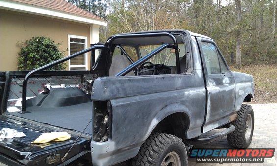 Gray 1995 Ford Bronco with roll cage, rear view