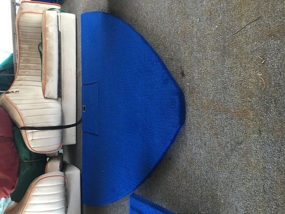 Stacked boat seats with orange trim and a blue carpeted section of flooring