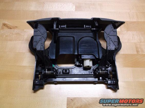 Black plastic center console trim piece with springs and levers