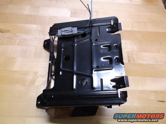 Black metal seat frame with wiring harness and connector, viewed from the side