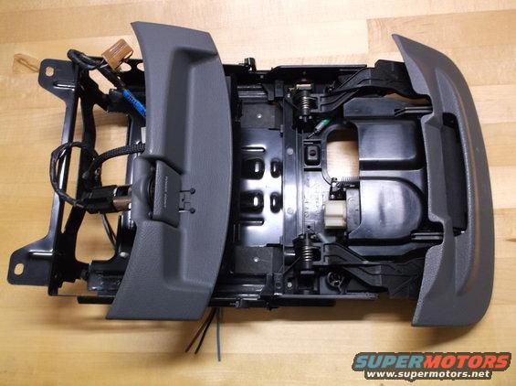 Car's center console assembly with wiring and power port visible