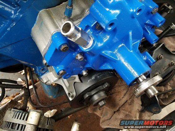 Blue painted engine water pump with timing marks visible on pulley