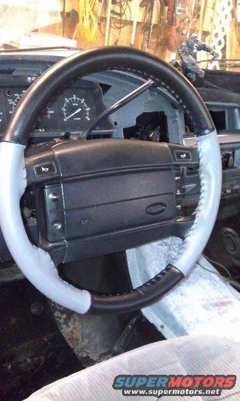 Steering wheel with two-tone leather wrap and visible stitching