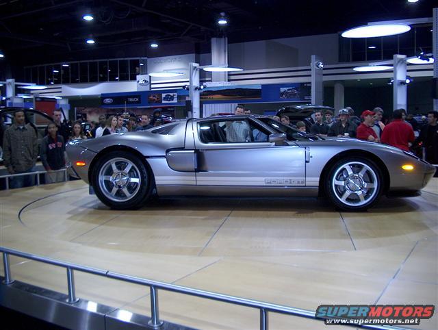 Silver Ford GT sports car on display, side view. "FORD GT" text visible on door