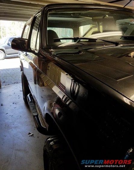 Black SUV parked in garage, another SUV visible in background