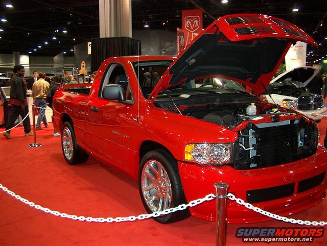 Red Dodge Ram SRT-10 pickup truck with hood open, chrome wheels, on red carpet