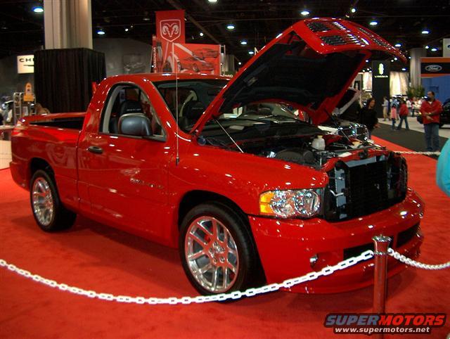 Red pickup truck with hood open, showing engine and grille