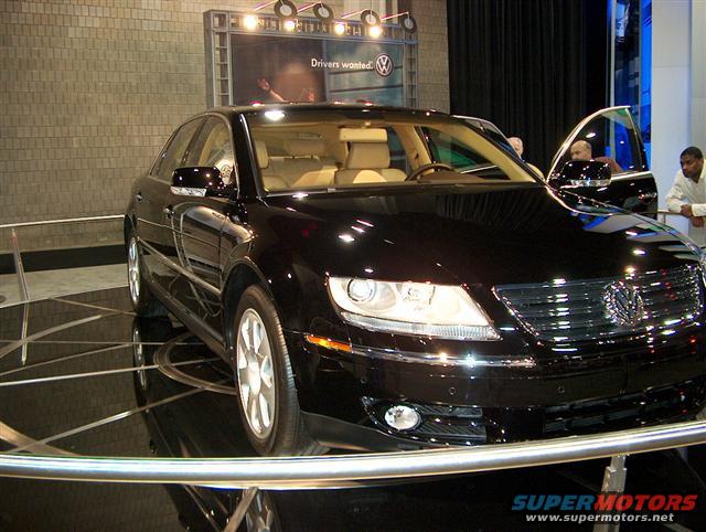 Black Volkswagen sedan with tan interior, front 3/4 view, on display