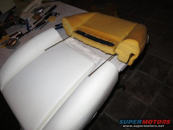 Car seat foam and metal frame disassembled on a table with tools nearby