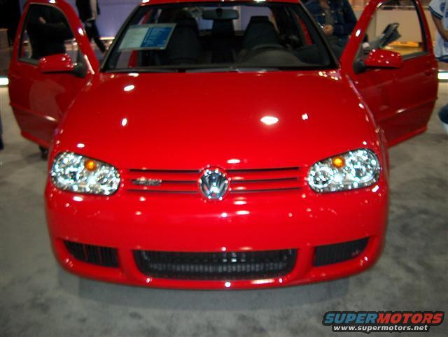 Front view of a red Volkswagen Golf GTI with doors open. Has a sticker on the windshield