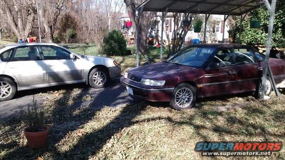 Maroon 1994 Subaru Legacy sedan parked under a carport