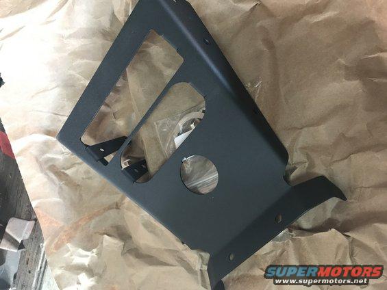 Black metal bracket with cutouts, resting on brown paper
